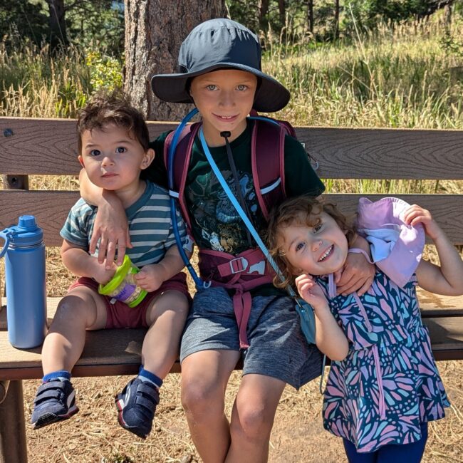 Three children sitting on a bench