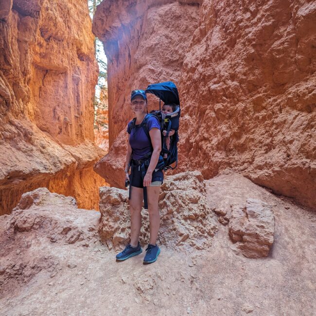 A person with a backpack hiking in a canyon