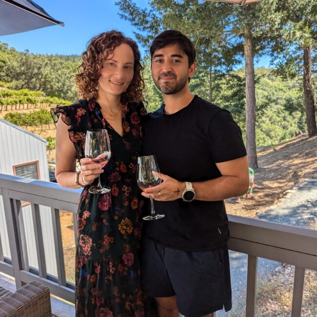 A woman and man drinking wine on a porch